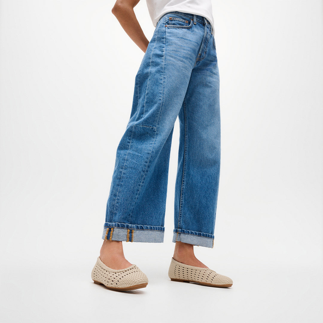 Woman wearing FitFlop DELICATO Woven PU Ballerinas with a woven faux-leather upper, lightweight comfort, and ergonomic support.