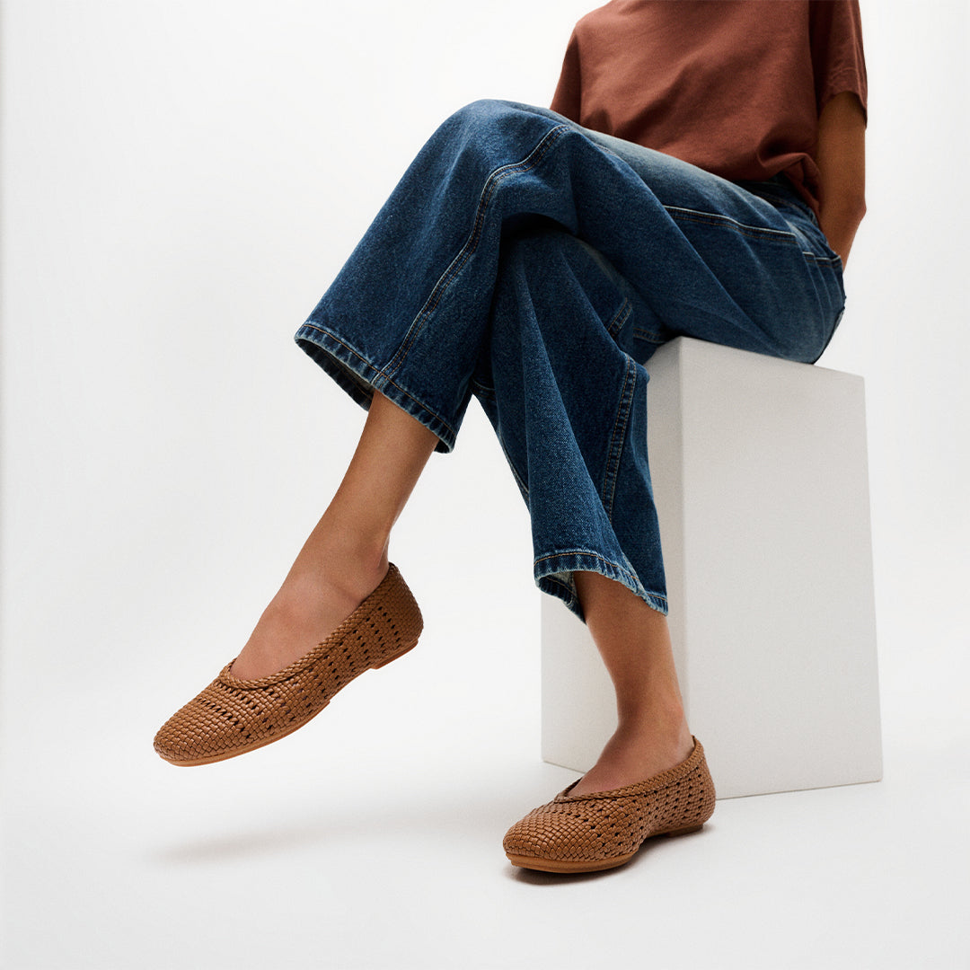 Woman wearing FitFlop DELICATO Woven PU Ballerinas with a woven faux-leather upper, lightweight comfort, and ergonomic support.