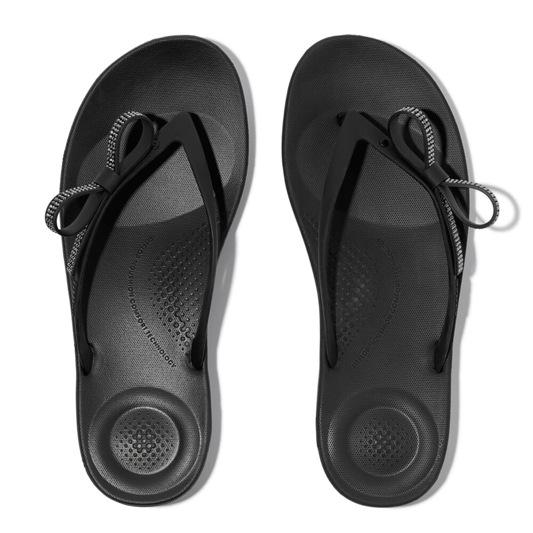 iQUSHION Glitz-Bow flip-flops with cushioned footbed, anatomically shaped straps, delicate bow detail, waterproof and lightweight.