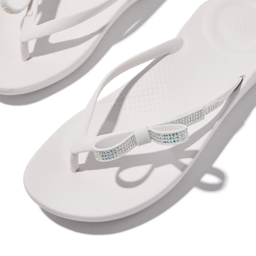 iQUSHION Glitz-Bow flip-flops with cushioned footbed, anatomically shaped straps, delicate bow detail, waterproof and lightweight.