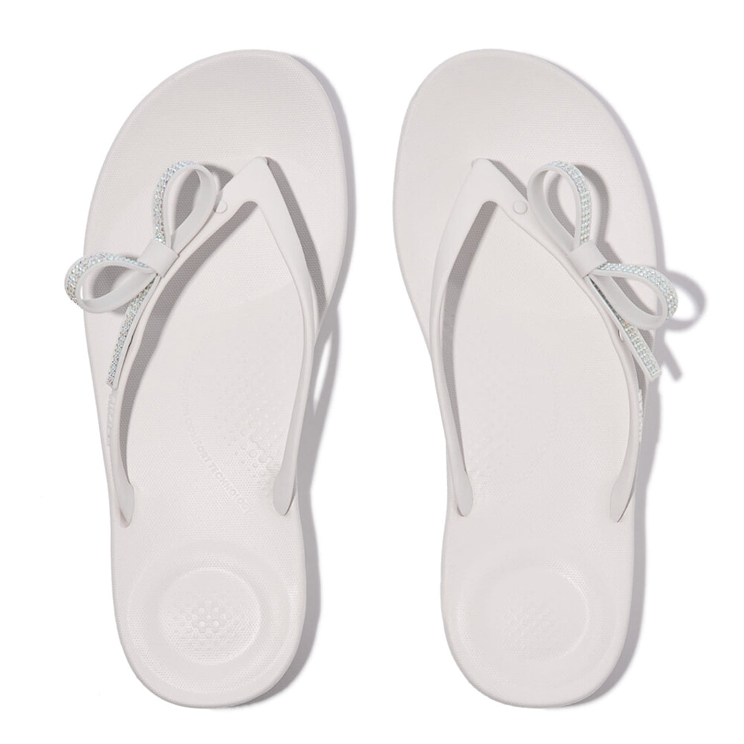 iQUSHION Glitz-Bow flip-flops with cushioned footbed, anatomically shaped straps, delicate bow detail, waterproof and lightweight.