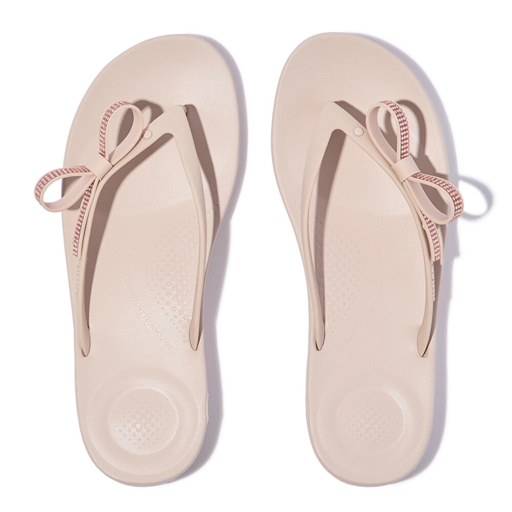 iQUSHION Glitz-Bow flip-flops with cushioned footbed, anatomically shaped straps, delicate bow detail, waterproof and lightweight.