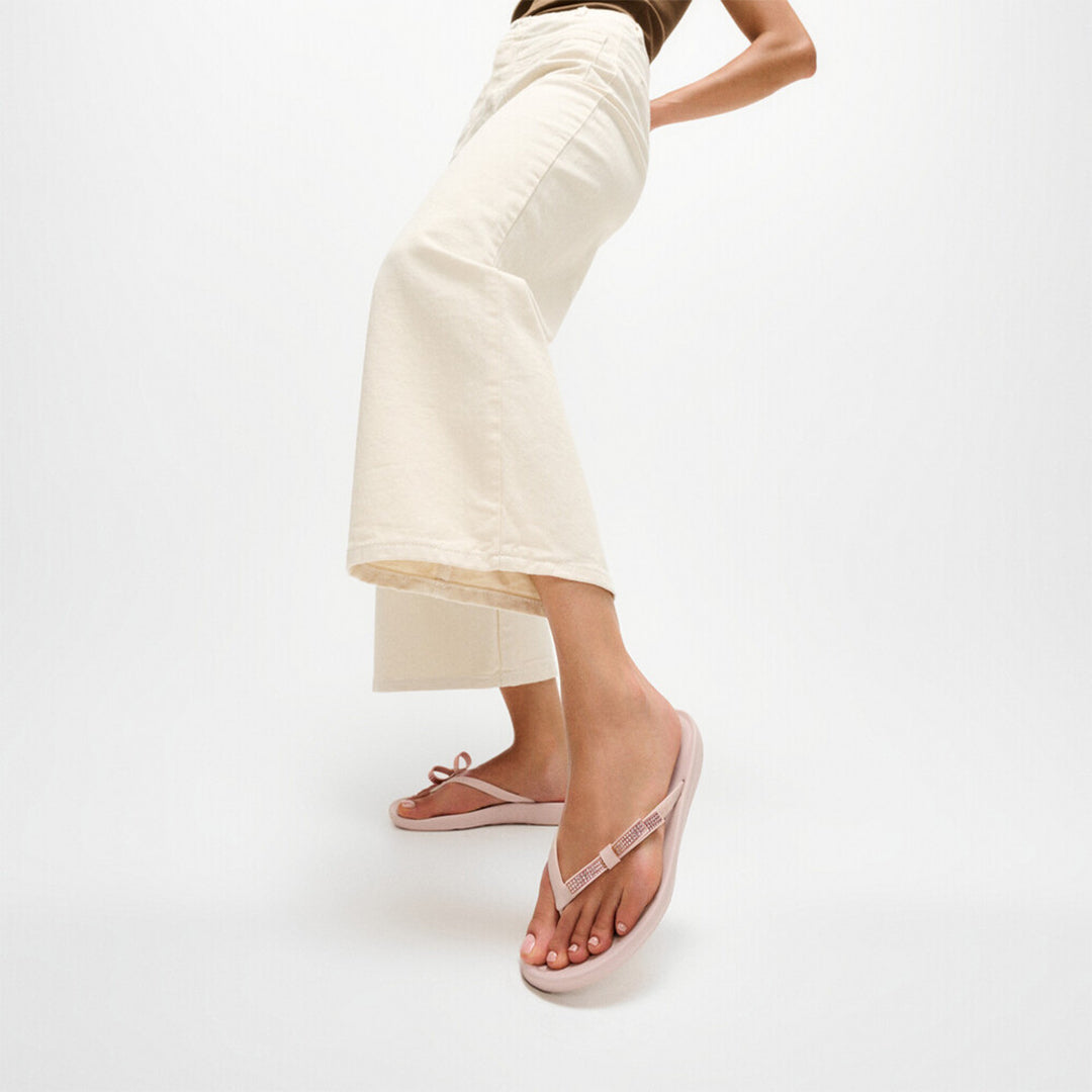 iQUSHION Glitz-Bow flip-flops with cushioned footbed, anatomically shaped straps, delicate bow detail, waterproof and lightweight.