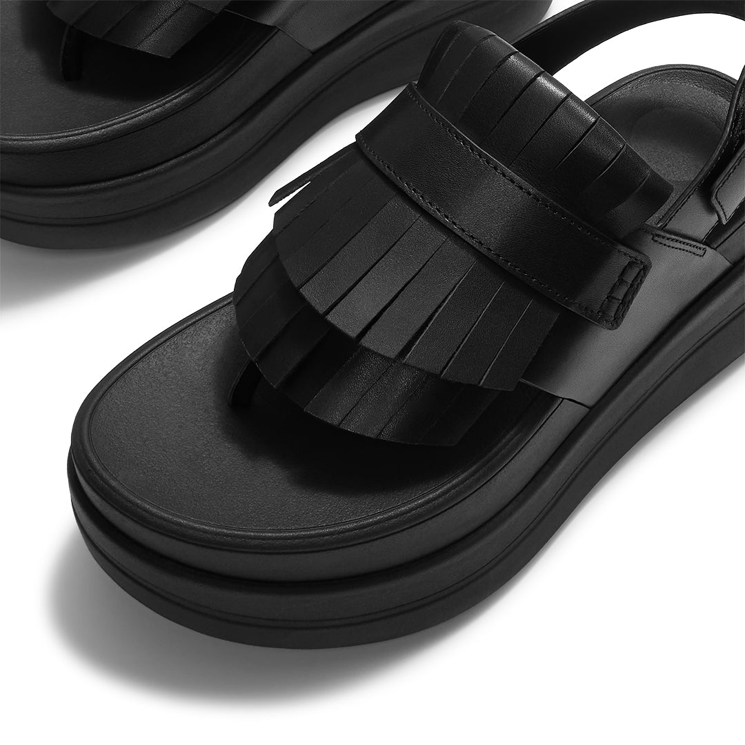 Close-up of FitFlop F-MODE STACK Leather Fringe Toe-Post Sandals featuring smooth leather straps, fringe detailing, and buckle fastening.