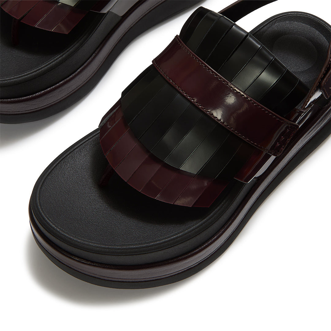 Close-up of FitFlop F-MODE STACK Leather Fringe Toe-Post Sandals featuring smooth leather straps, fringe detailing, and buckle fastening.