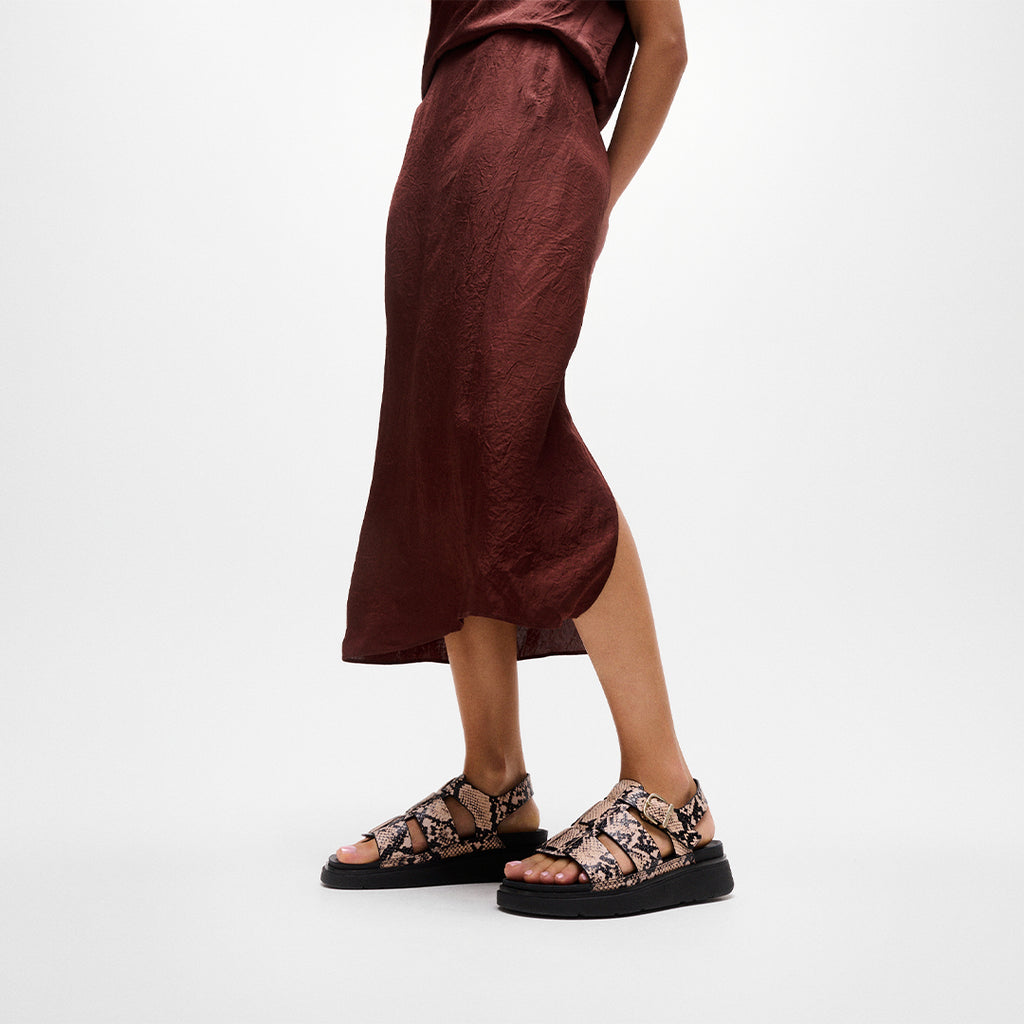 Woman wearing FitFlop GEN-FF Snake Fisherman Sandals with textured snake detailing, adjustable ankle strap and supportive cushioned sole.