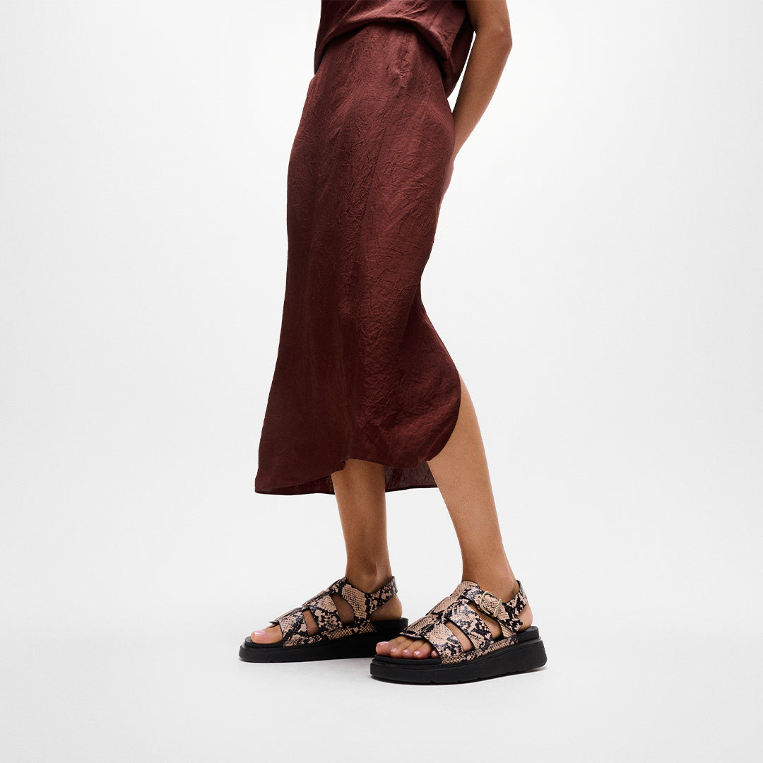 Woman wearing FitFlop GEN-FF Snake Fisherman Sandals with textured snake detailing, adjustable ankle strap and supportive cushioned sole.