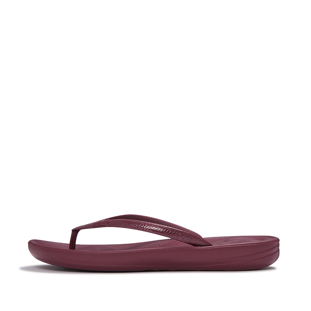 Side view of FitFlop iQUSHION Glitter Flip-Flops showcasing shimmering straps, slim lightweight sole, and ergonomic design.