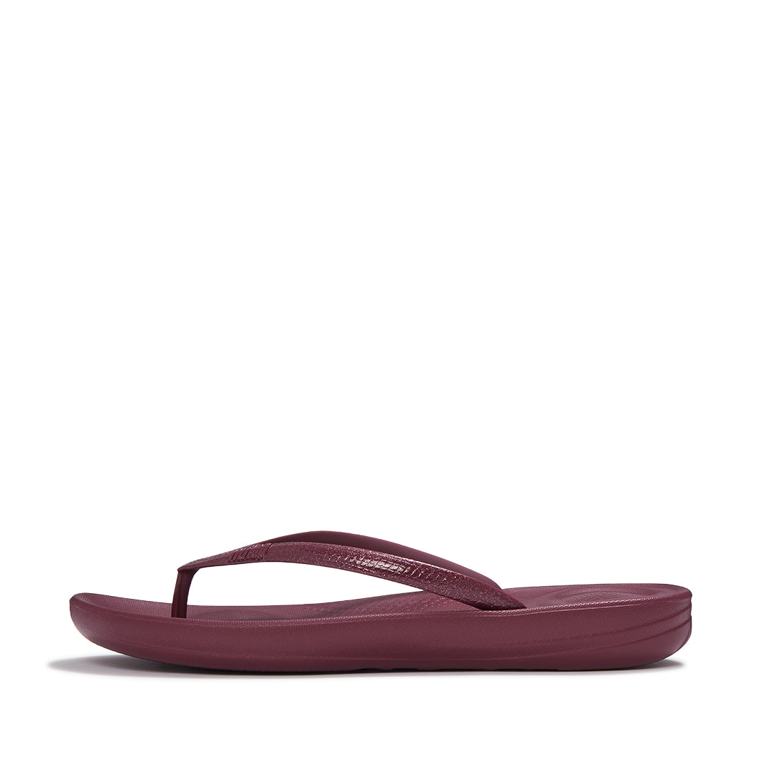 Side view of FitFlop iQUSHION Glitter Flip-Flops showcasing shimmering straps, slim lightweight sole, and ergonomic design.