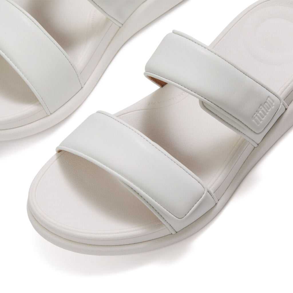 Close-up of FitFlop F-MODE Go Adjustable Slides featuring metallic faux-leather straps and soft padded detailing.