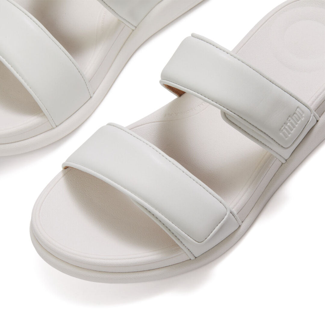 Close-up of FitFlop F-MODE Go Adjustable Slides featuring metallic faux-leather straps and soft padded detailing.