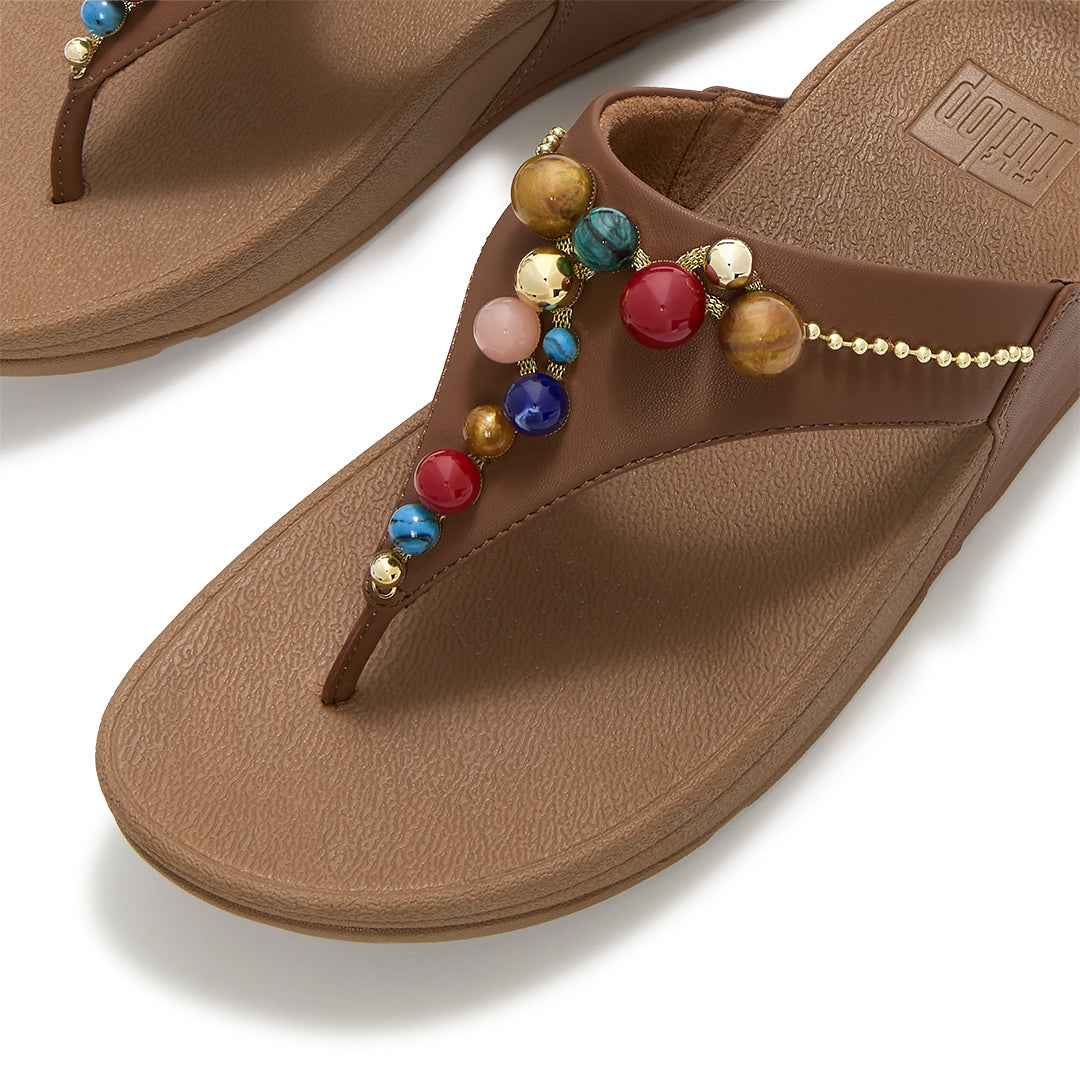 Close-up of FitFlop LULU Beaded Toe-Post Sandals showcasing tonal metallic and resin bead embellishments across the triangular vamp.