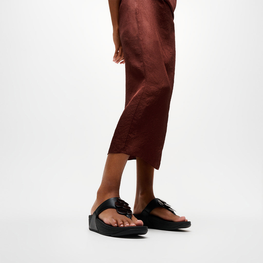 Woman wearing FitFlop LULU Disc-Cluster Toe-Post Sandals with embellished leather straps and supportive cushioned sole.