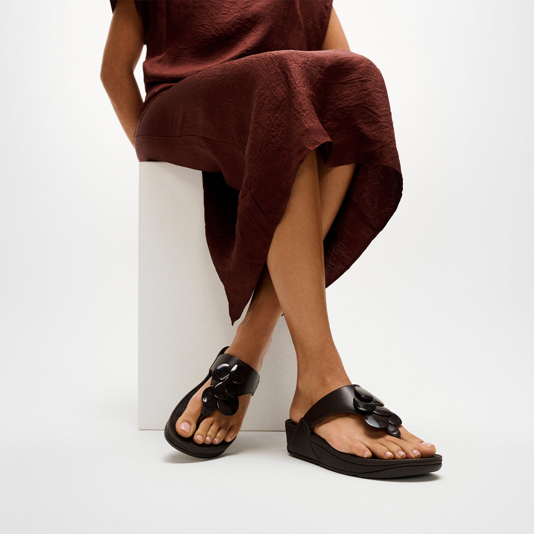 Woman wearing FitFlop LULU Disc-Cluster Toe-Post Sandals with embellished leather straps and supportive cushioned sole.