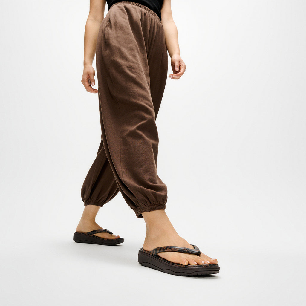 Woman wearing FitFlop RELIEFF Leopard Recovery Sandals with lightweight EVA construction and supportive cushioned footbed.