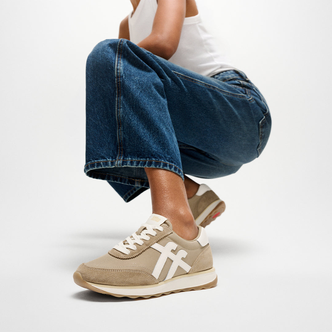 Woman wearing FitFlop RETRO-Q FF Sneakers with vintage-inspired styling, premium suede panels, and lightweight cushioned comfort.