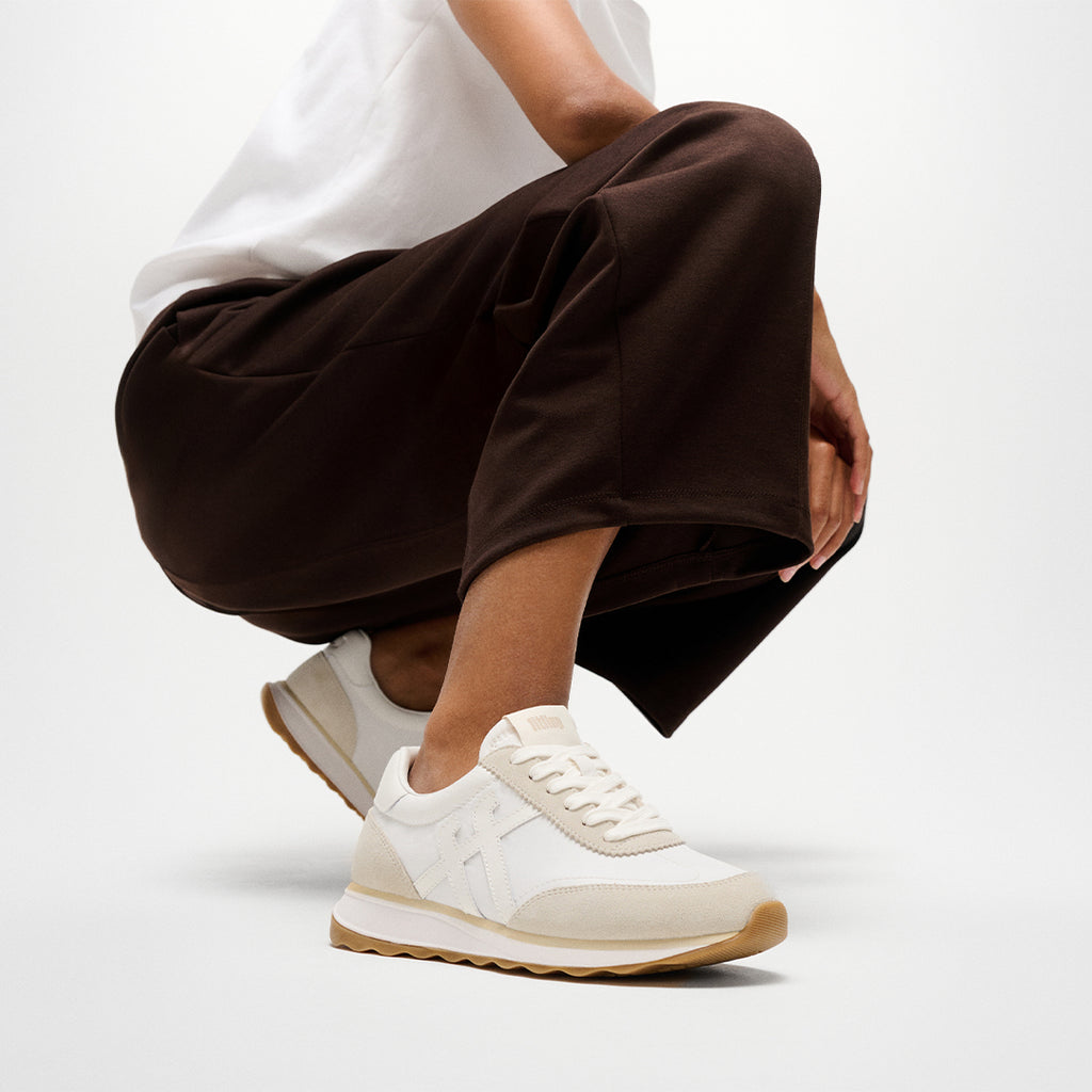 Woman wearing FitFlop RETRO-Q FF Sneakers with vintage-inspired styling, premium suede panels, and lightweight cushioned comfort.